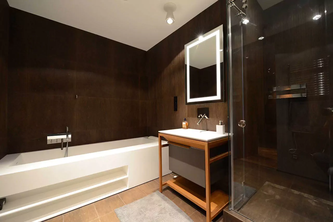 Modern bathroom in a hotel room with a rectangular bathtub and an evervue lighted mirror in Dubai.