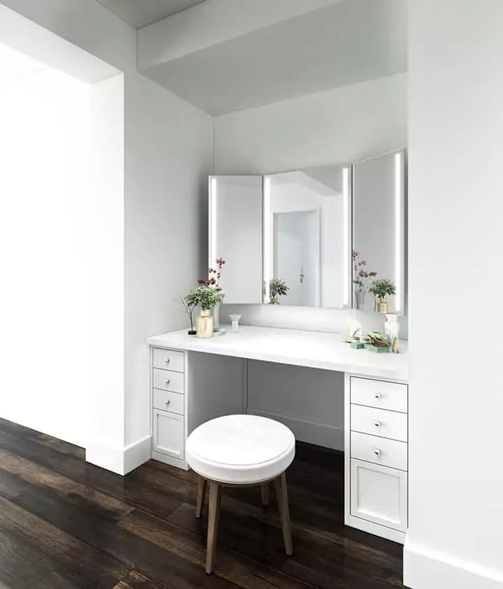 Trifold vanity mirror above a wooden cabinet with a marble countertop in a dressing room in Dubai.