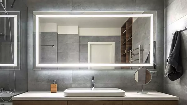 Mini of vanity mirror in Dubai attached to a concrete wall above a sink on a granite countertop.