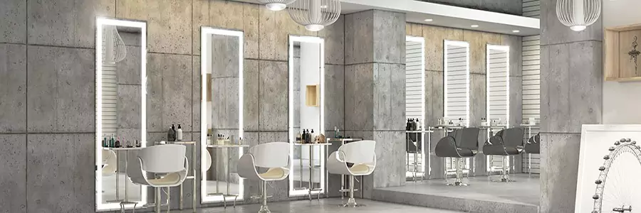 Bespoke Lighted Mirrors mounted on a concrete wall with grid lines and salon chairs in Sharjah.
