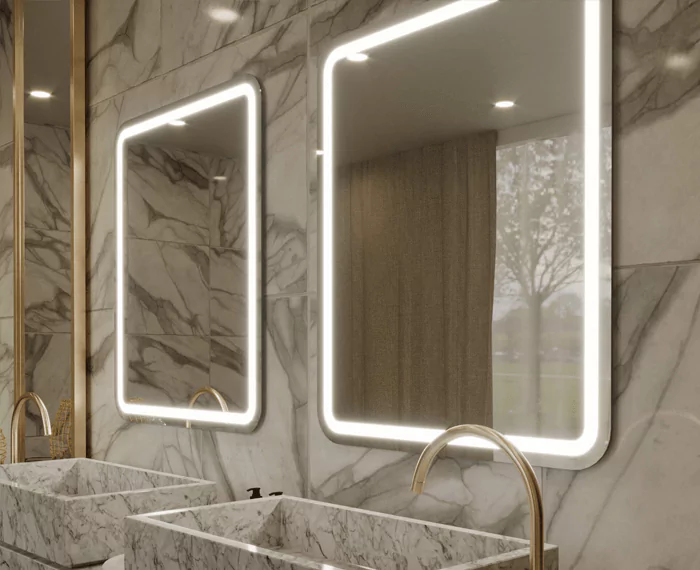 Two boxy custom lighted mirrors mounted on a marble wall and two marble basin in Sharjah.