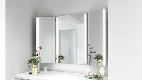 Icon of trifold lighted mirror above a cabinet with a marble countertop in a dressing room in Dubai.